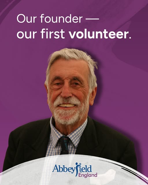 An older man with grey hair and a beard smiles in front of a purple background featuring the text: Our founder — our first volunteer, inspiring others to explore volunteering opportunities. The Abbeyfield England logo is at the bottom.