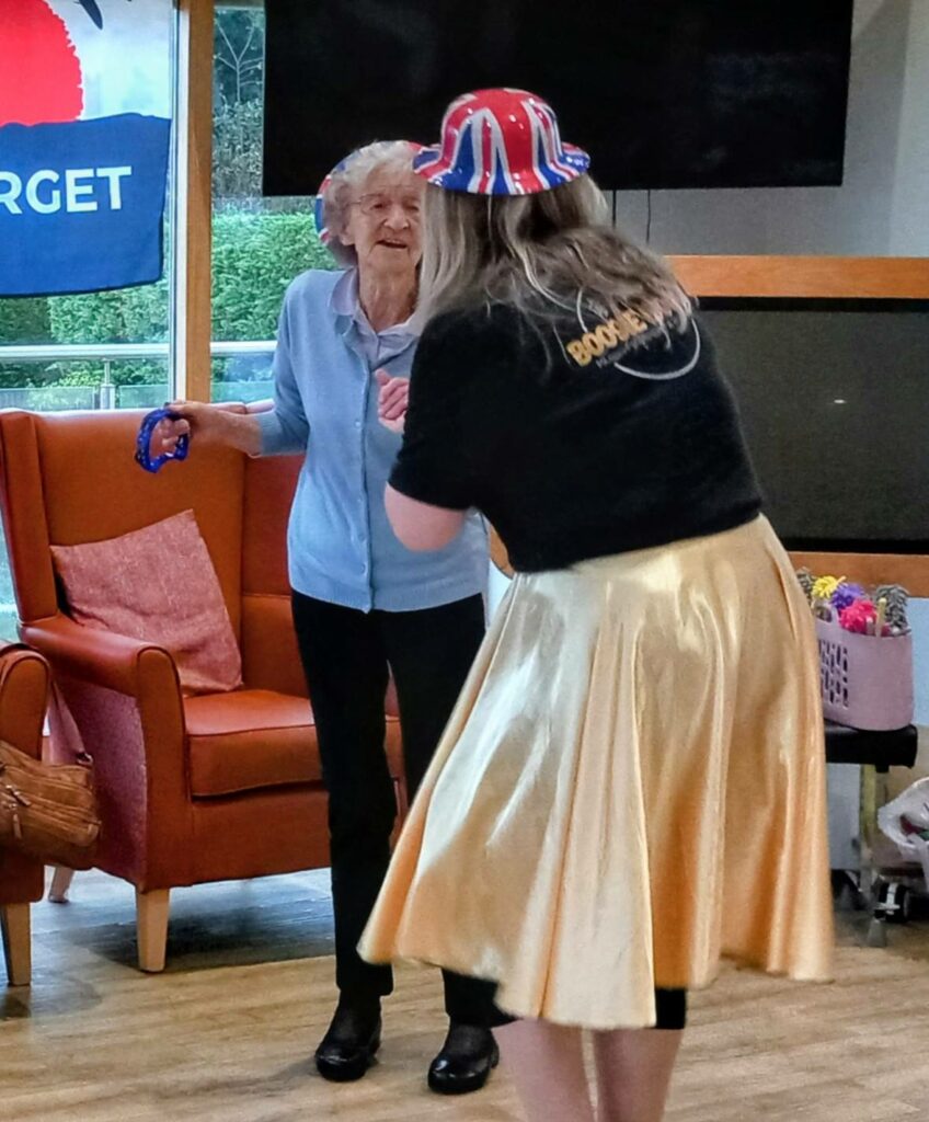 An elderly woman beams as she holds a tambourine, while another lady in a gold skirt and Union Jack hat brings British fun and boogie woogie vibes to the lounge.